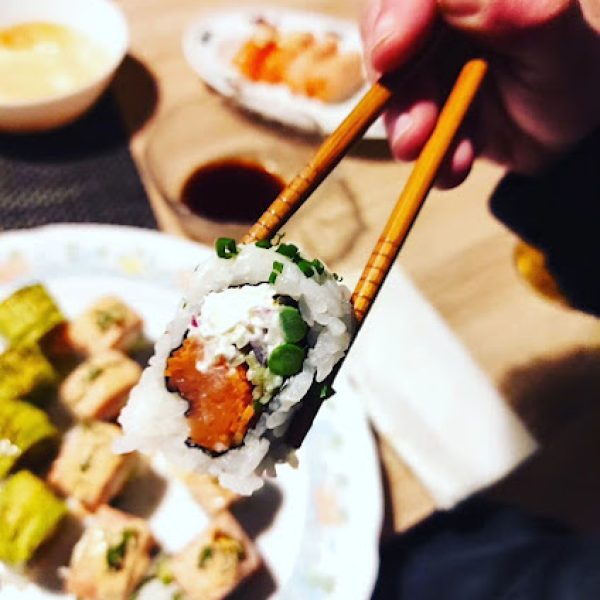 Porción de sushi sujetada con palillo